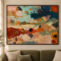 Close frontal view of Earth & Tide abstract wall art in a thin dark brown frame above an olive sofa.