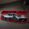 AMG Street Phantom die-cut rug — silver AMG hypercar beneath the AMG wordmark, cut to shape on a red border, on a dark concrete floor