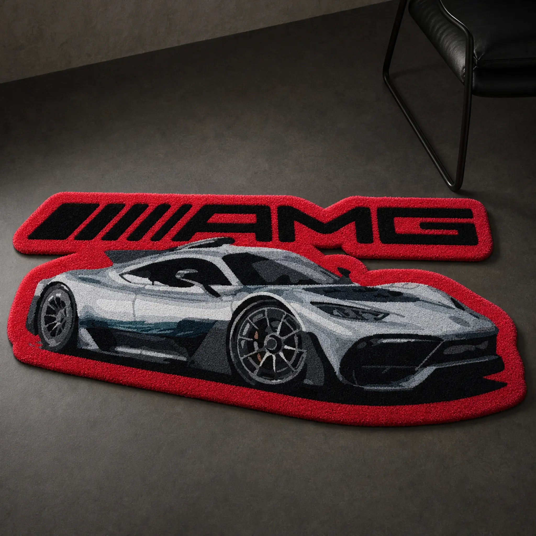 AMG Street Phantom die-cut rug — silver AMG hypercar beneath the AMG wordmark, cut to shape on a red border, on a dark concrete floor