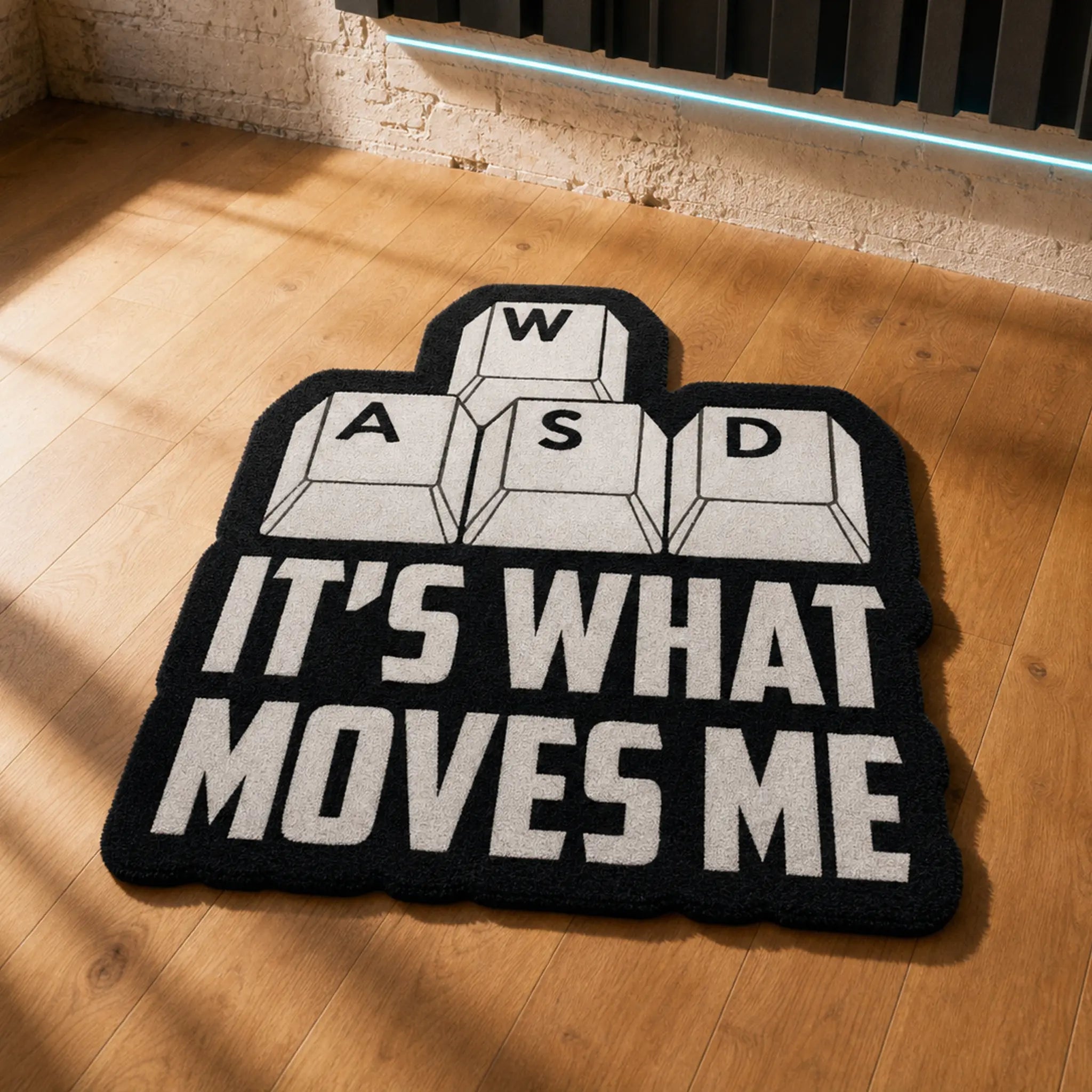 GAMER'S GPS die-cut rug — WASD keycaps above the words IT'S WHAT MOVES ME, cut to the shape of the design with black edge binding