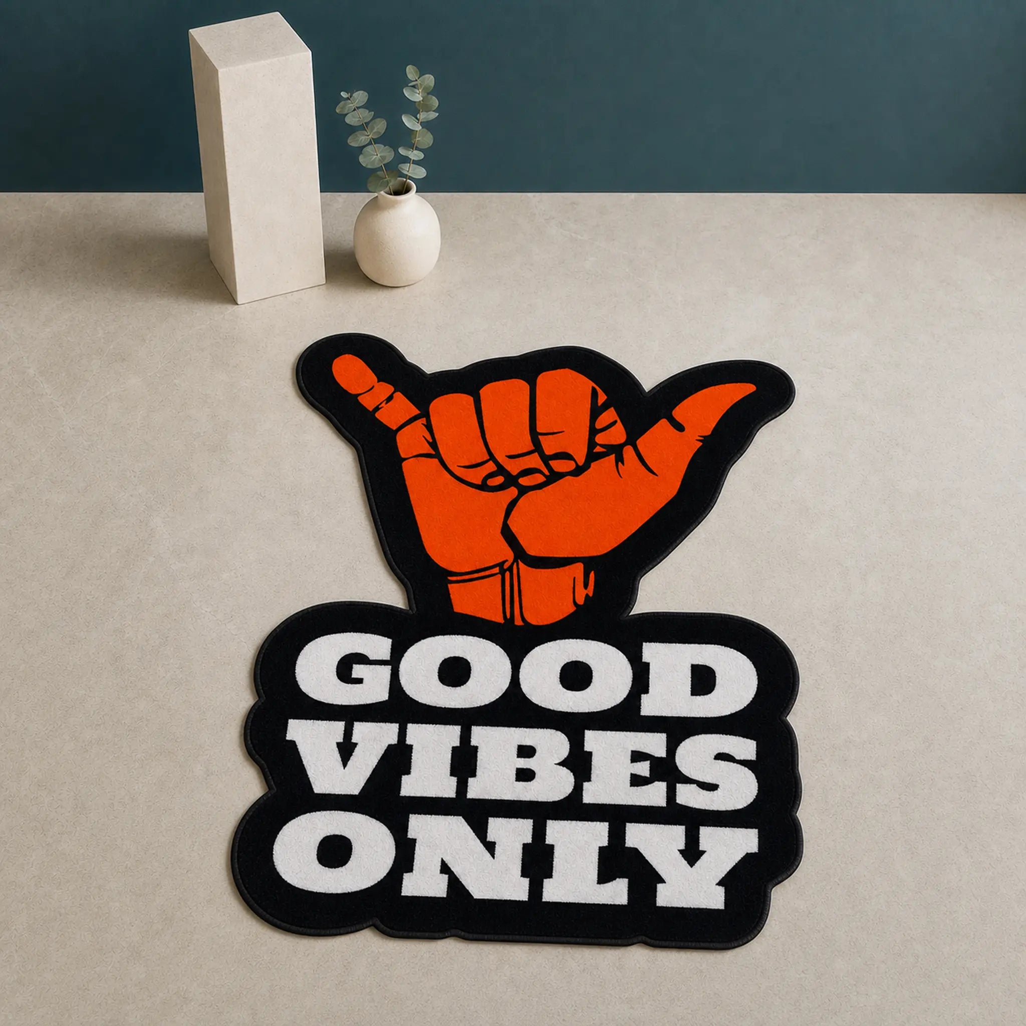 Good Vibes Only die-cut rug — orange shaka hand above GOOD VIBES ONLY in white block type on black, cut to the shape of the design with black edge binding