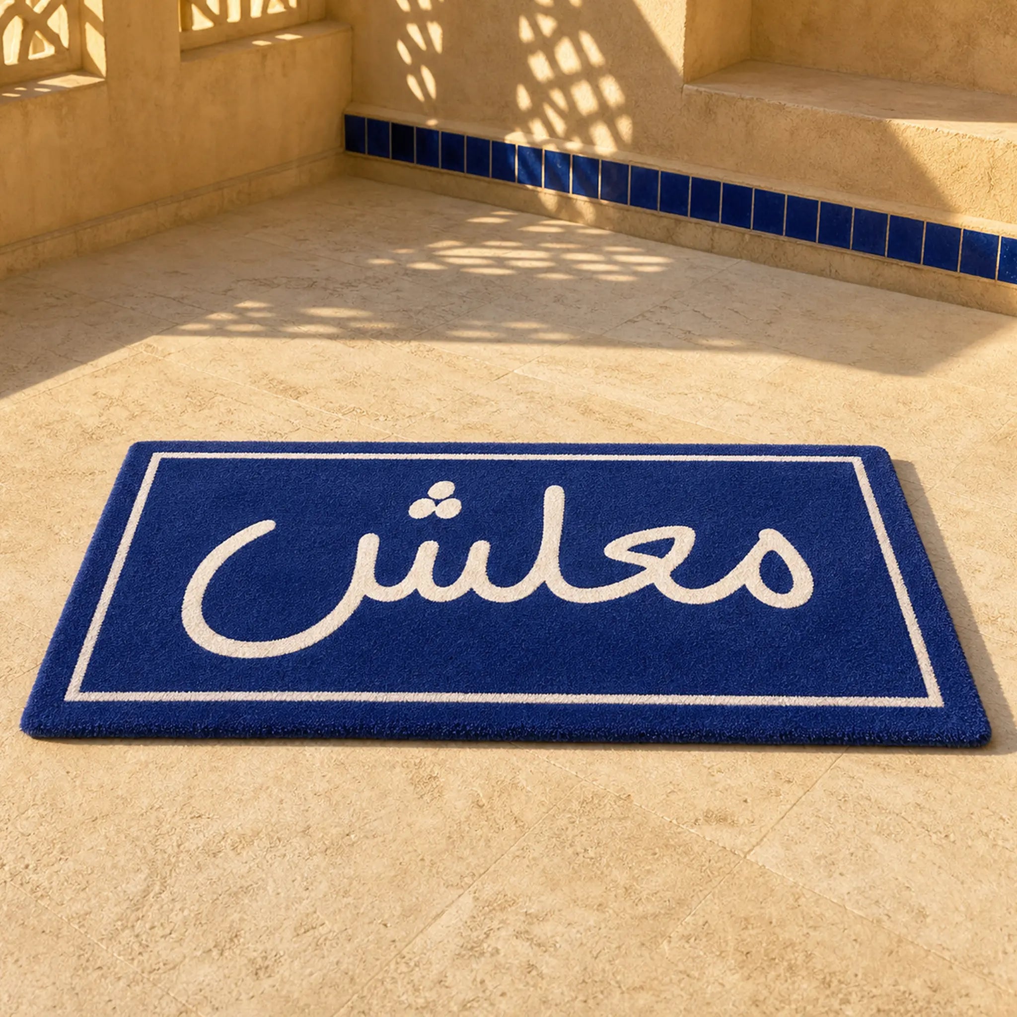 MAALESH VIBES die-cut rug — the Arabic word معلش in white on a navy street-sign plaque, cut to the rectangle with black edge binding