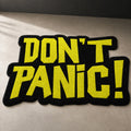 DON'T PANIC die-cut rug — yellow lettering on black faux fur, cut to the shape of the words with black edge binding