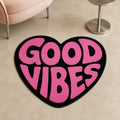 Pink Positive Heart die-cut rug — GOOD VIBES in pink retro bubble type inside a black heart, cut to the heart shape with black edge binding