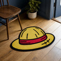 Straw Hat Legacy die-cut rug — gold straw hat with a red band and stitched patch on the brim, cut to the hat shape with black edge binding
