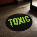Toxic Drip die-cut rug — TOXIC in dripping acid-green slime lettering on a black circle, cut to the circle with black edge binding