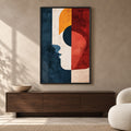 Front view of The Ember Muse, a geometric profile in navy, ivory, ochre and rust red in a slim black frame above a dark wooden sideboard.