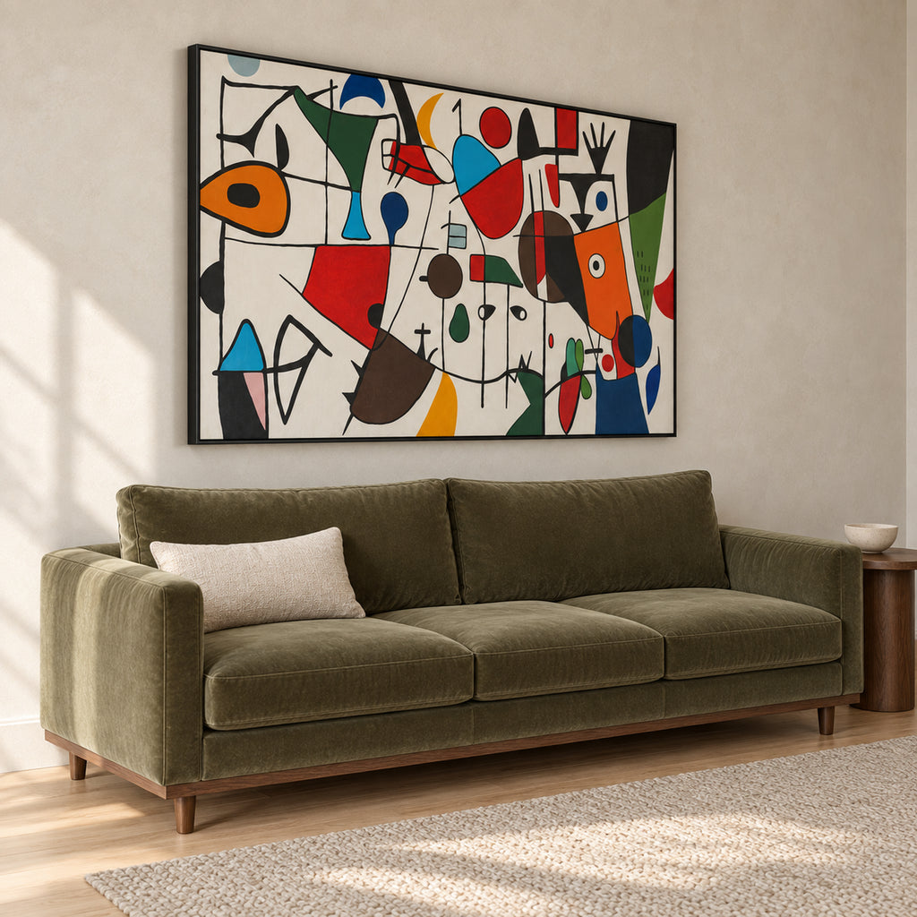 Angled view of Chromatic Play showing the complete abstract artwork, slim black frame and frame depth above the olive sofa.