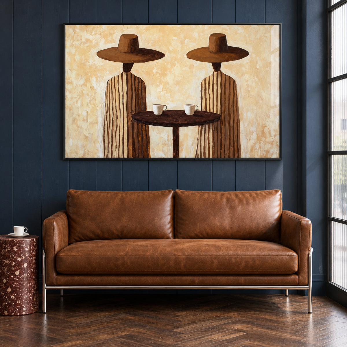 Front view of Coffee for Two black-framed wall art, showing two figures in broad brown hats sharing coffee above a brown sofa.