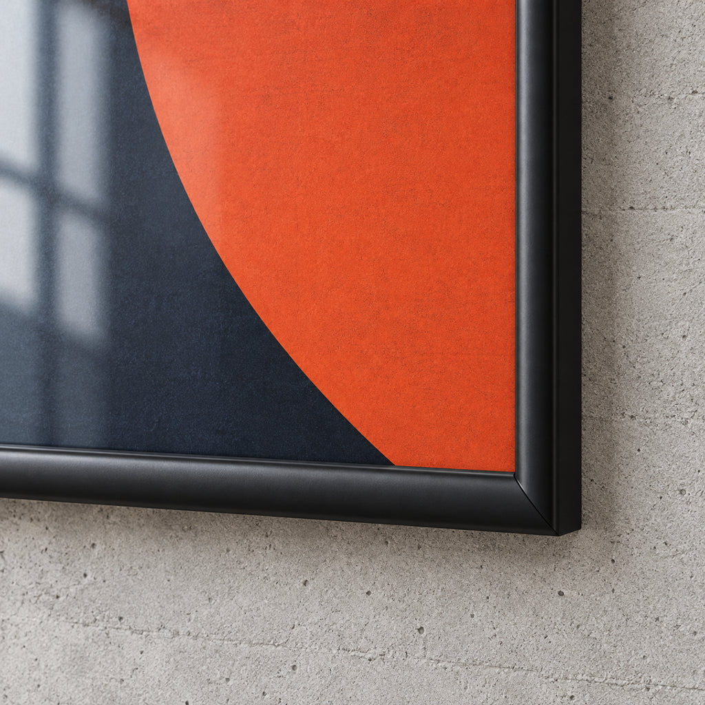 Frame detail of Ember & Sage, showing the rounded black profile and mitred corner beside burnt orange and deep ink-blue curves.