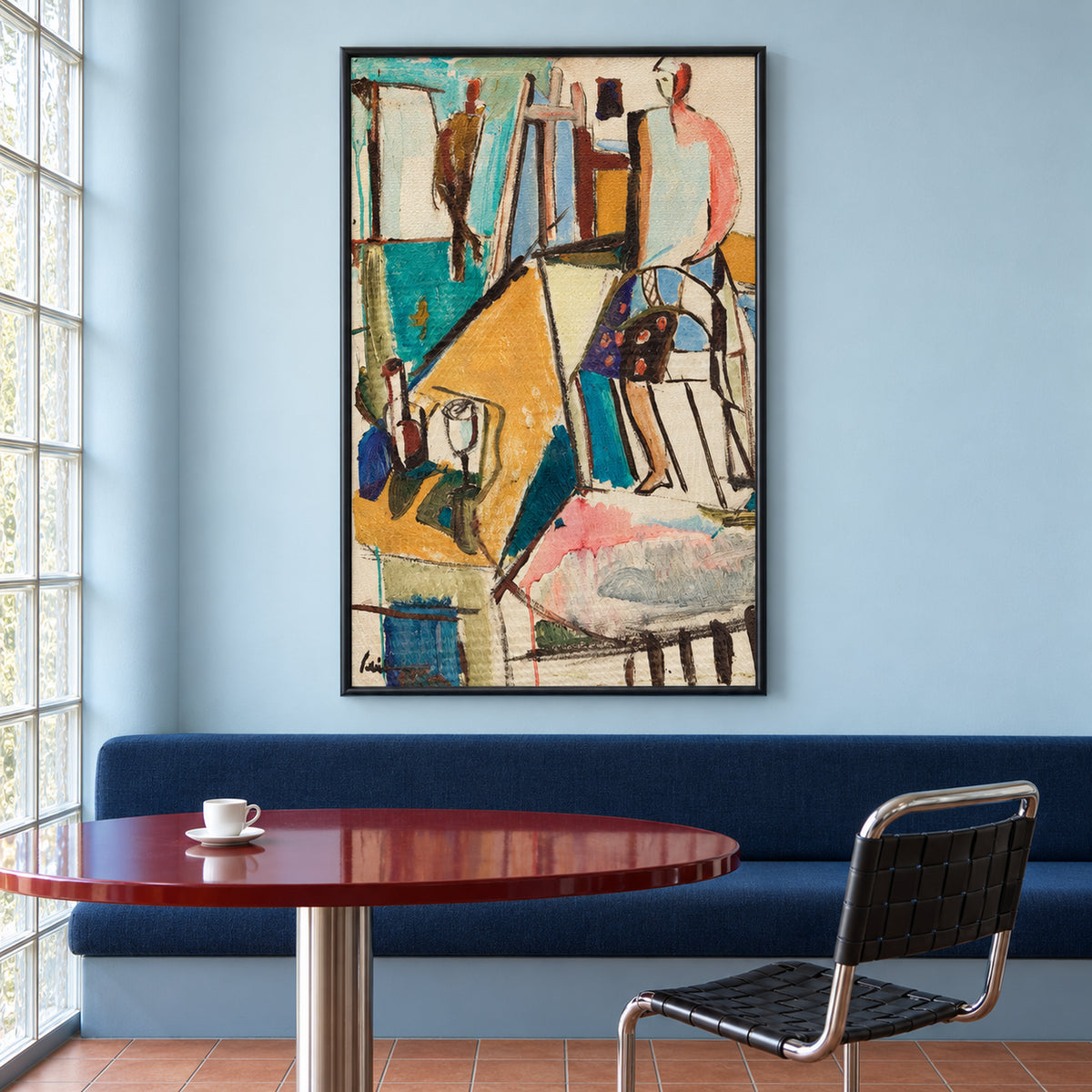 Front view of Studio Reverie in a slim black frame, showing a colourful artist's studio above a blue banquette and red round table.