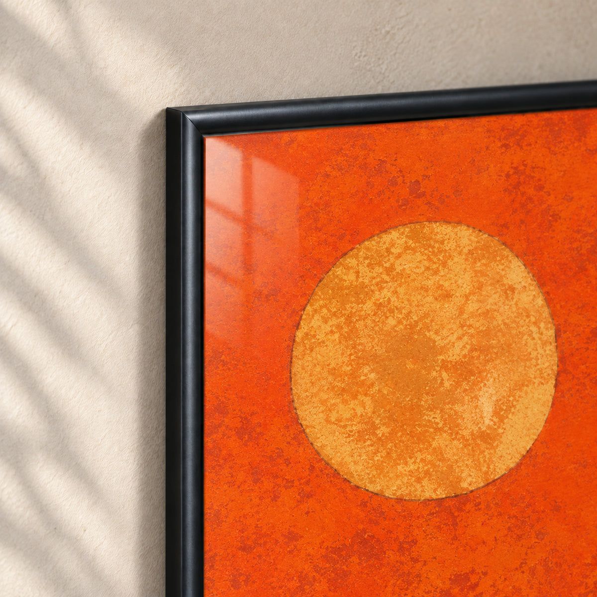 Ember Trail frame detail showing the rounded satin-black wooden molding, mitered corner and glass over the orange print and ochre sun.