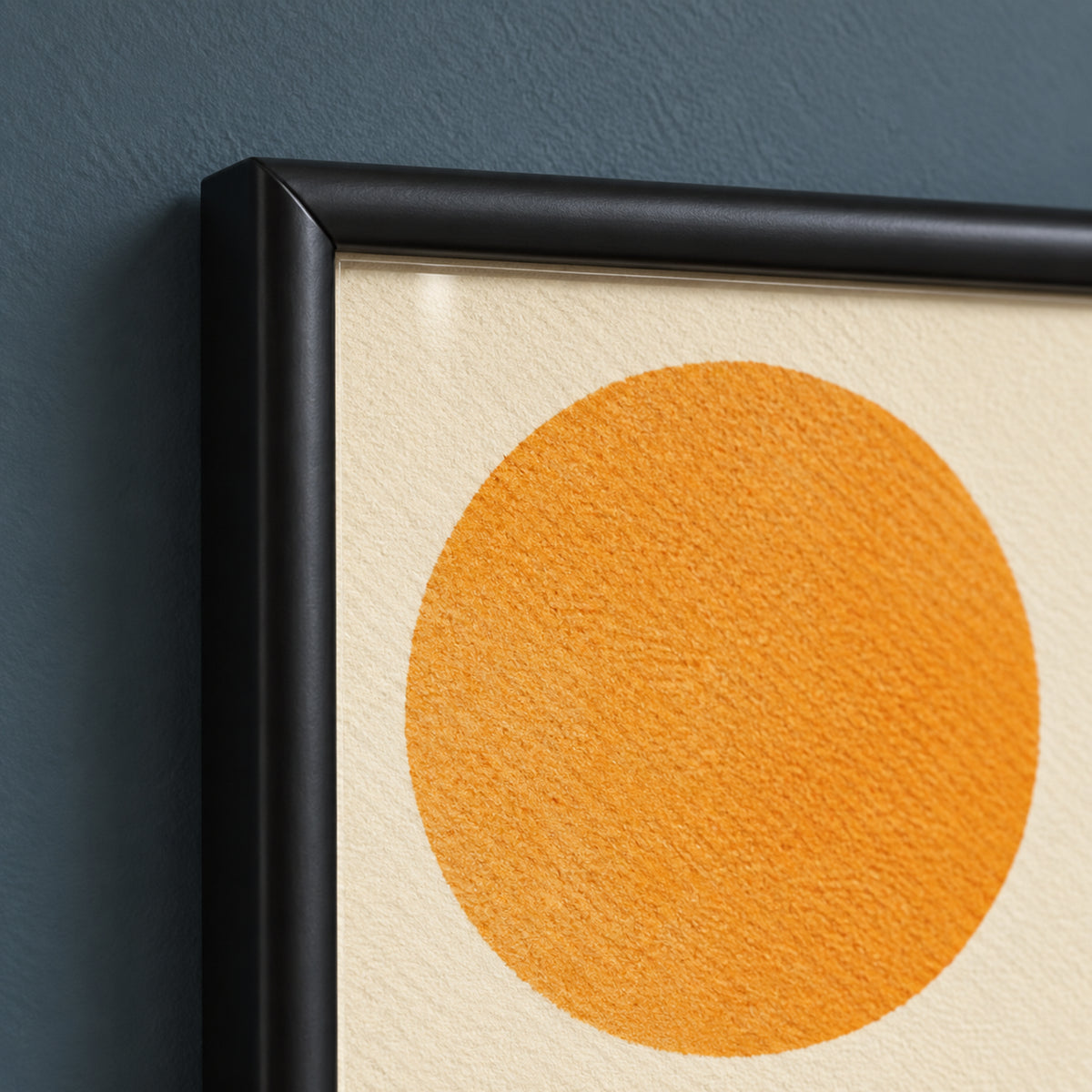 Frame detail of Kindred Rhythm showing the rounded black wooden profile and mitred corner beside the ochre circle on ivory.
