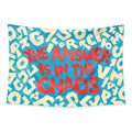 Hidden Order wall tapestry with coral lettering reading The answer is in the chaos and scattered cream letters on turquoise.