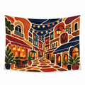 Lantern Lane wall tapestry with a winding café street, overhead string lights, a wall lantern, warm buildings and potted plants.