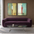Front view of Between Us: two black-framed artworks with slender ivory and red figures against turquoise, cream and pale yellow, above a plum sofa.