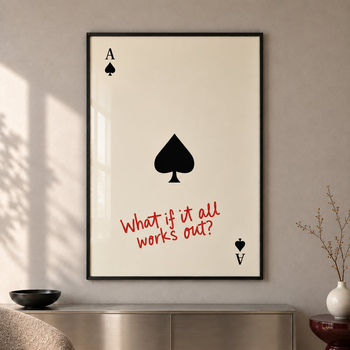 Frontal close-up of The Optimist’s Ace, showing the black spade, playing-card corner symbols and red handwritten quote, with all four black frame edges visible.