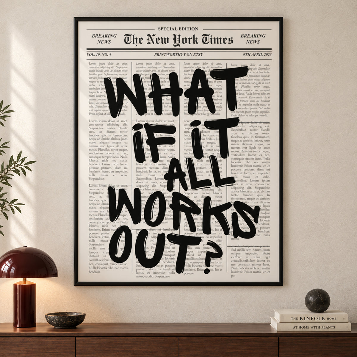 Frontal close-up of The Optimist’s Edition with black “What if it all works out?” lettering over an ivory newspaper layout; all four frame edges are visible.